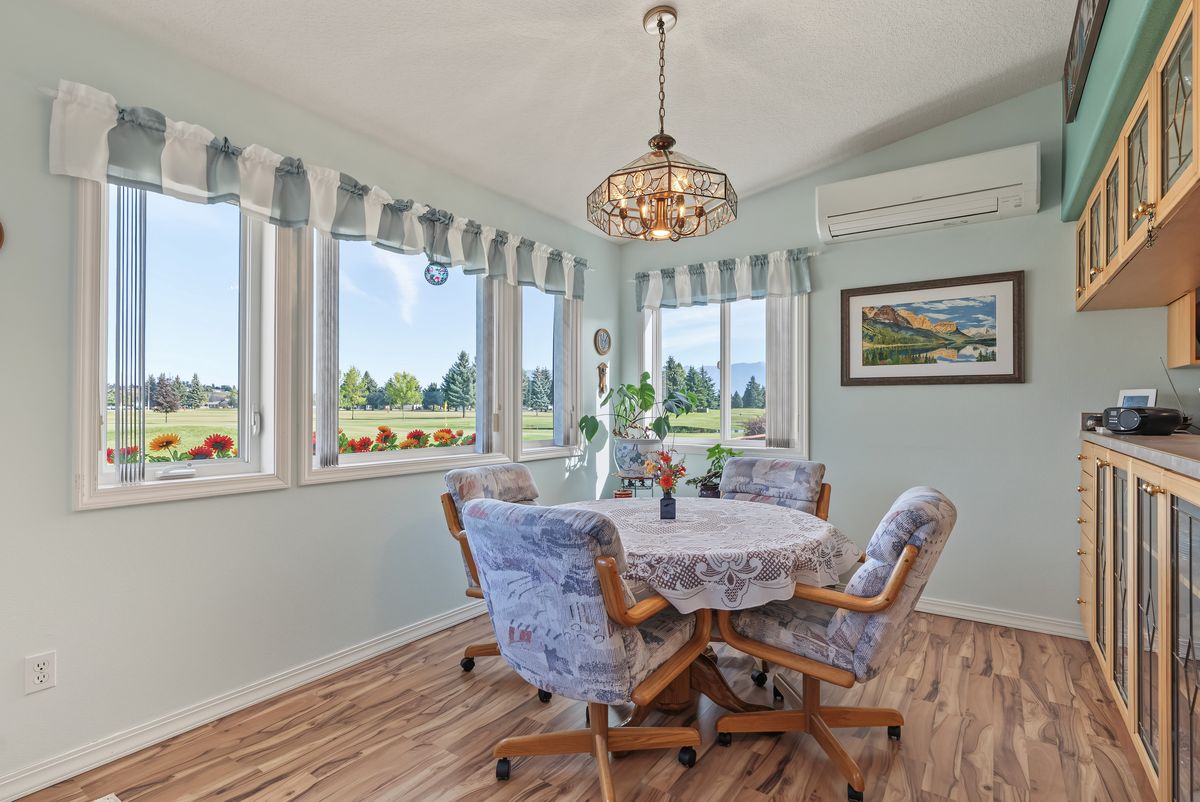 Dining nook with corner windows facing the course and a chandelier