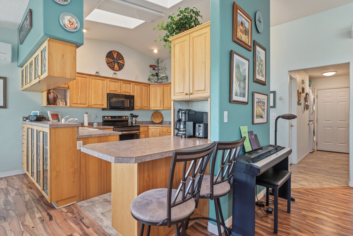 Kitchen with wood cabinetry, an electric range, and an over-the-range microwave