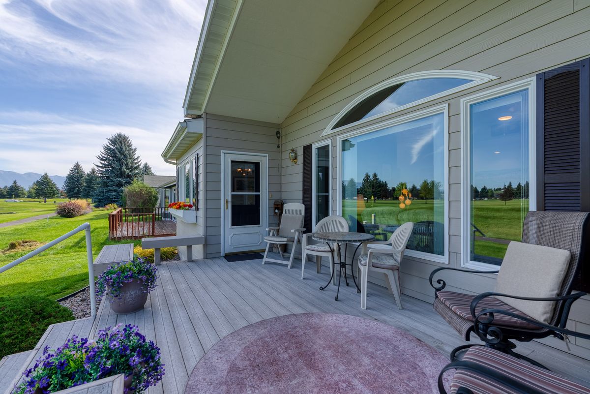Covered back deck with seating, looking out toward the course and the mountains