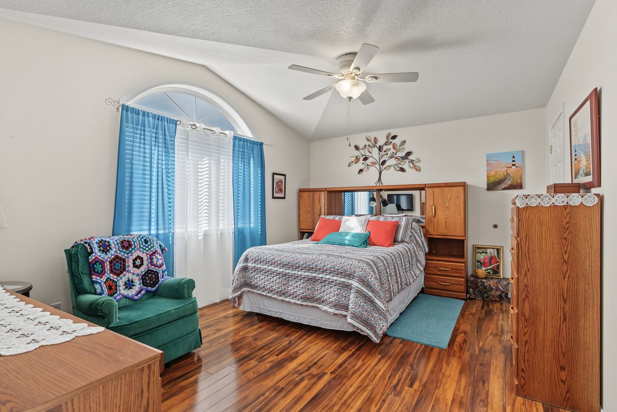 Primary bedroom with a vaulted ceiling and an arched window