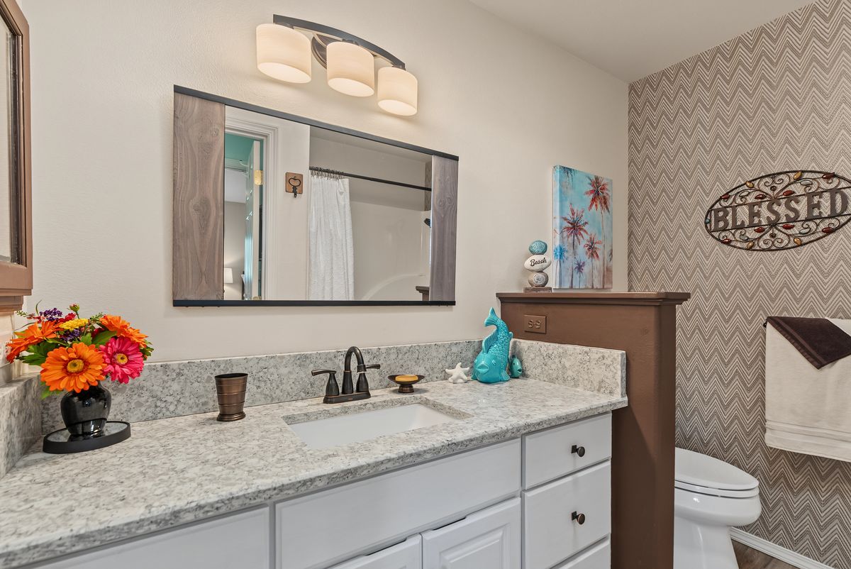 Bathroom with a wide vanity, a large mirror, and a tub and shower