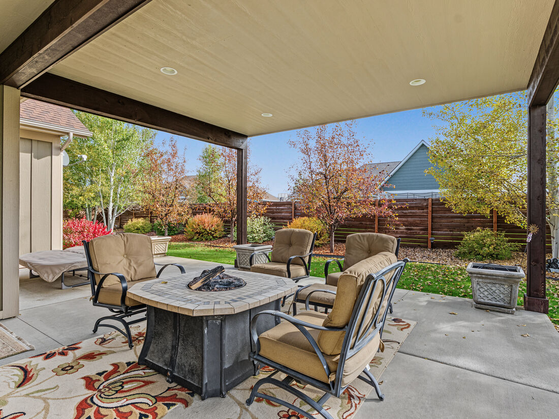 Oversized covered back patio with fire pit table and seating