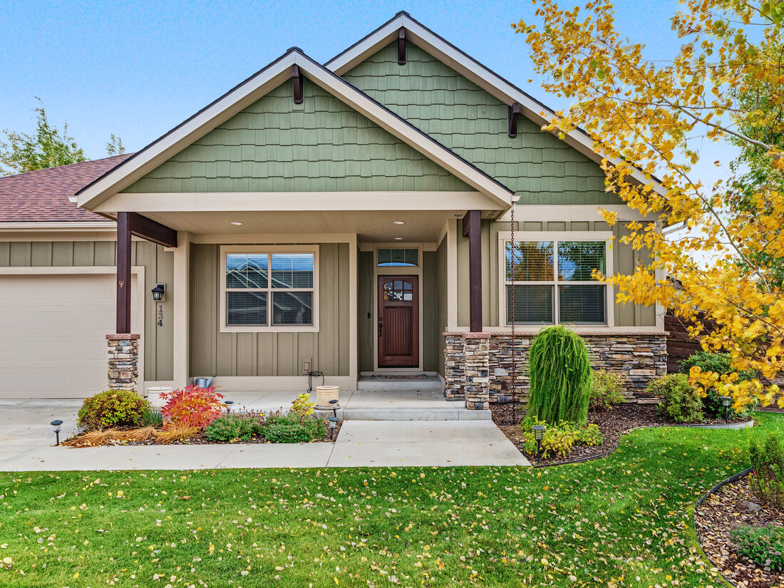 Front of the home at 134 E Swift Creek Way with stone accents, covered entry, and fall foliage