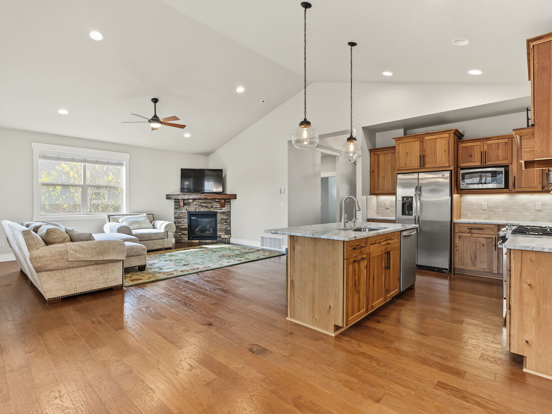 Kitchen with island seating, gas range, upgraded cabinetry, and leather-finished granite