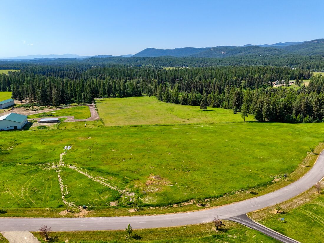 Aerial of open pasture and mountain views at River Ranch