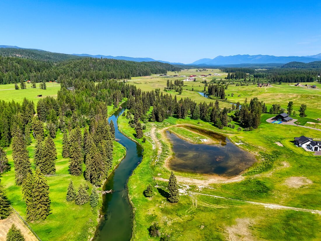 Aerial view of the Stillwater River, pond, and forest in the River Ranch community near Whitefish