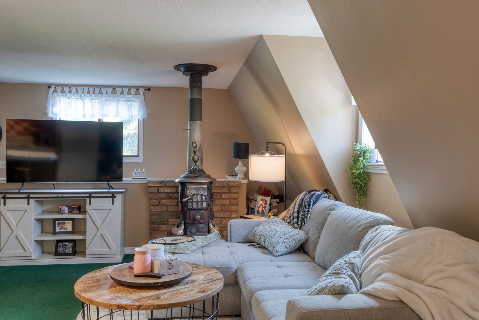 Guest apartment living area with wood stove and sectional seating