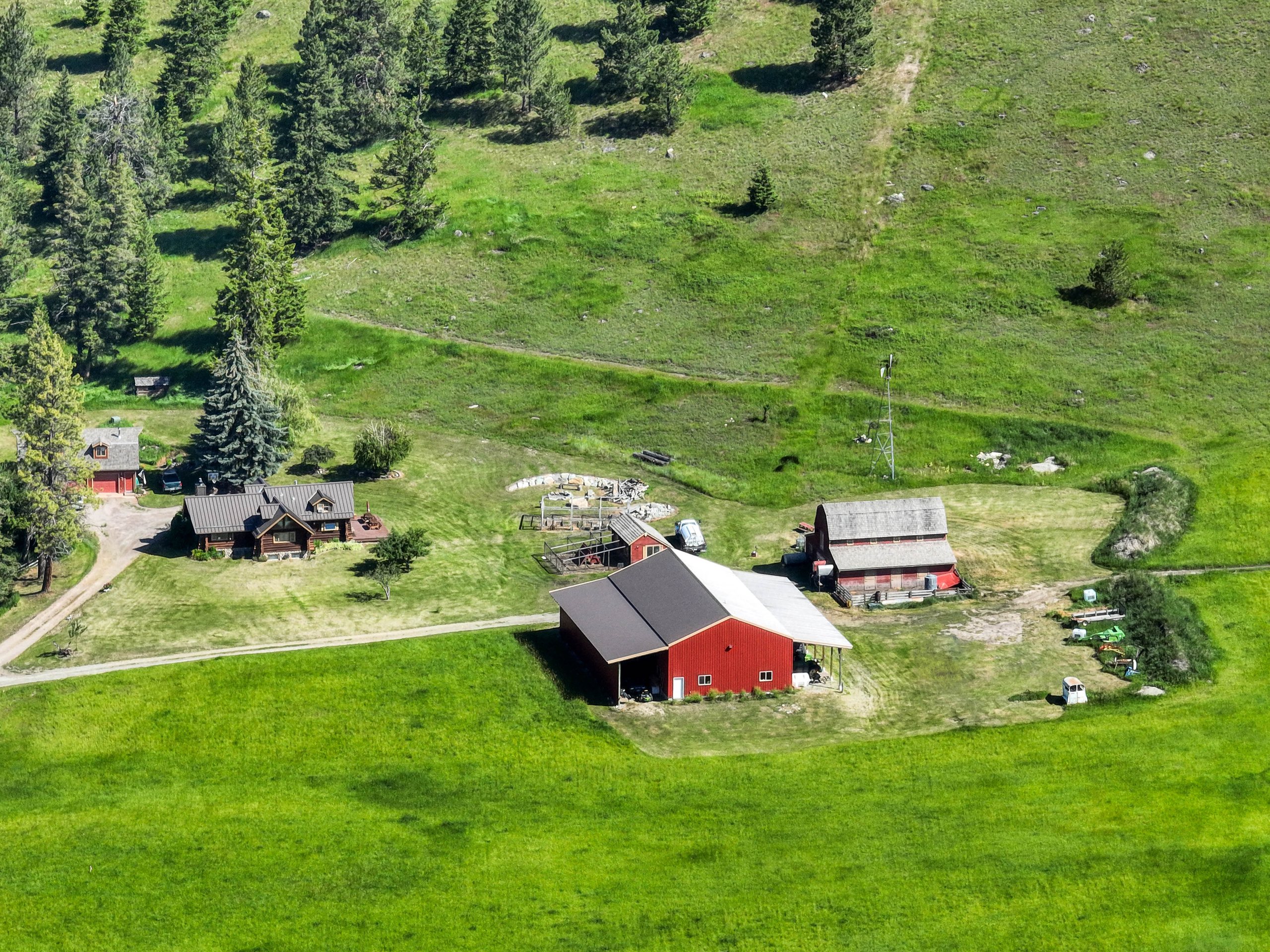 Aerial view of the home, barn, and red outbuildings amid open pasture