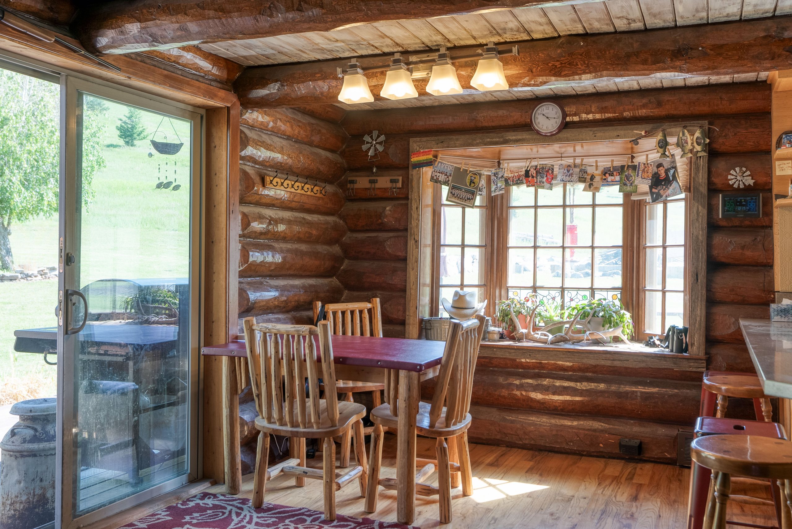 Dining area with log walls and sliding glass doors to the deck