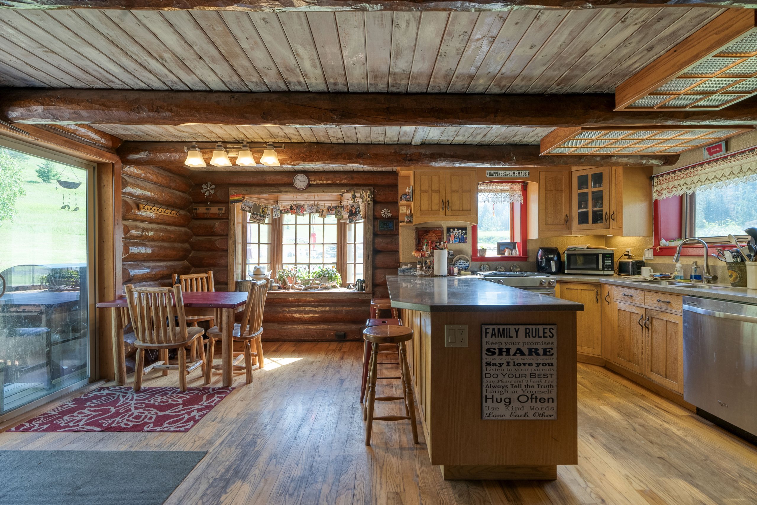 Log home kitchen with hardwood floors and timber walls