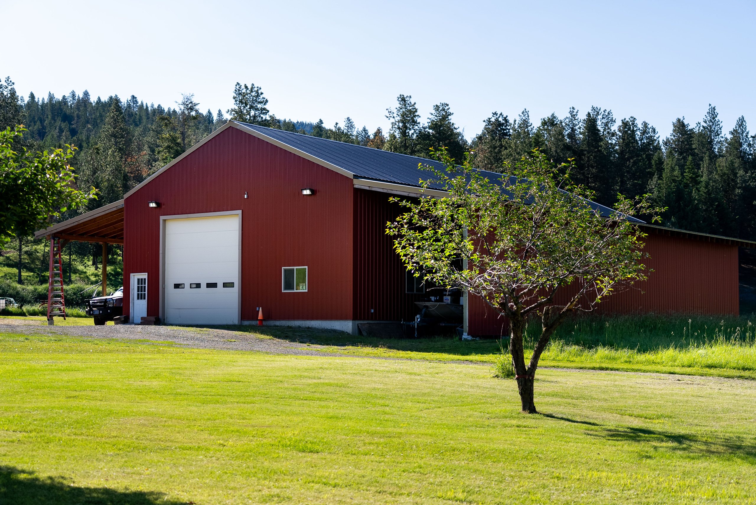 Large red shop building with overhead door and lean-tos