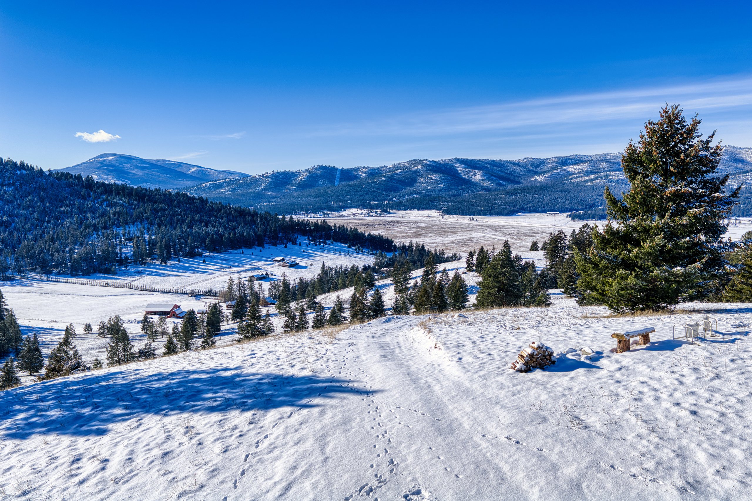 Open winter track leading toward the distant mountains, showing year-round access and big-sky views